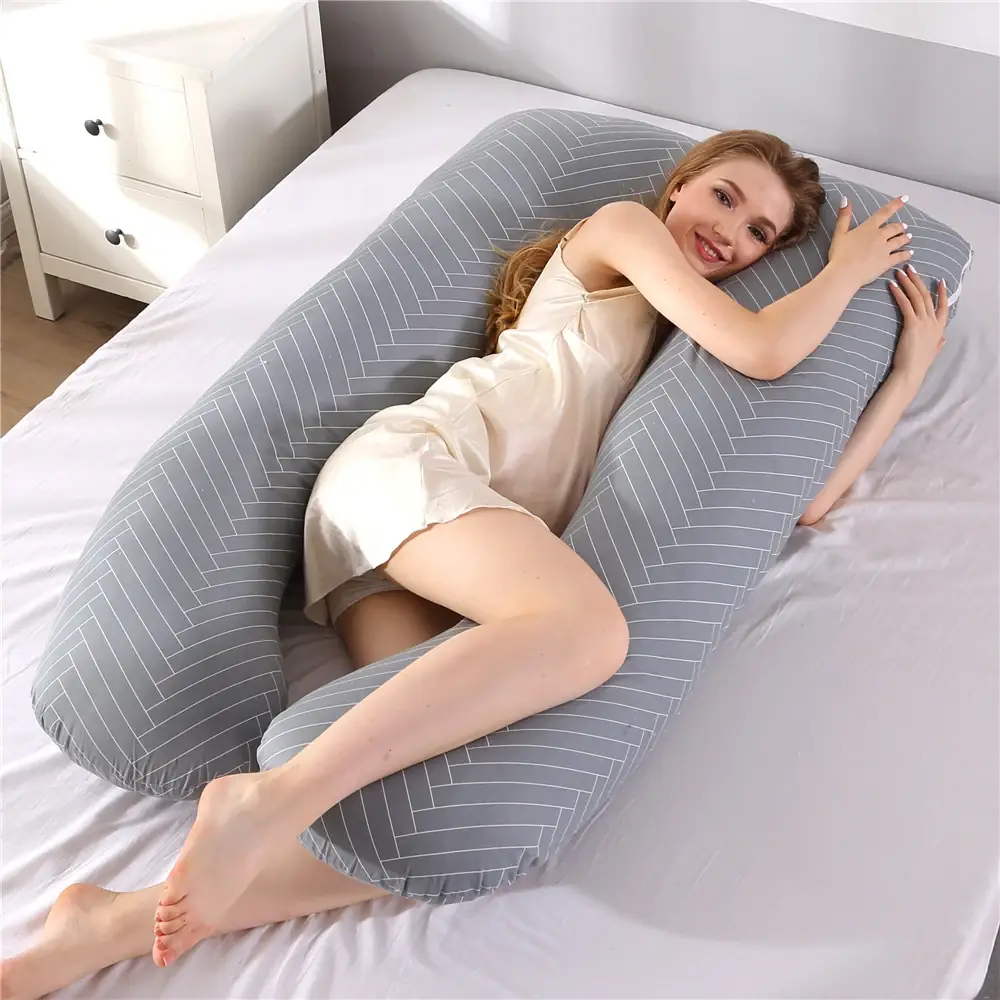 The Pregnancy Pillow U-shaped pregnancy pillow in Herringbone Grey, laid out on a bed