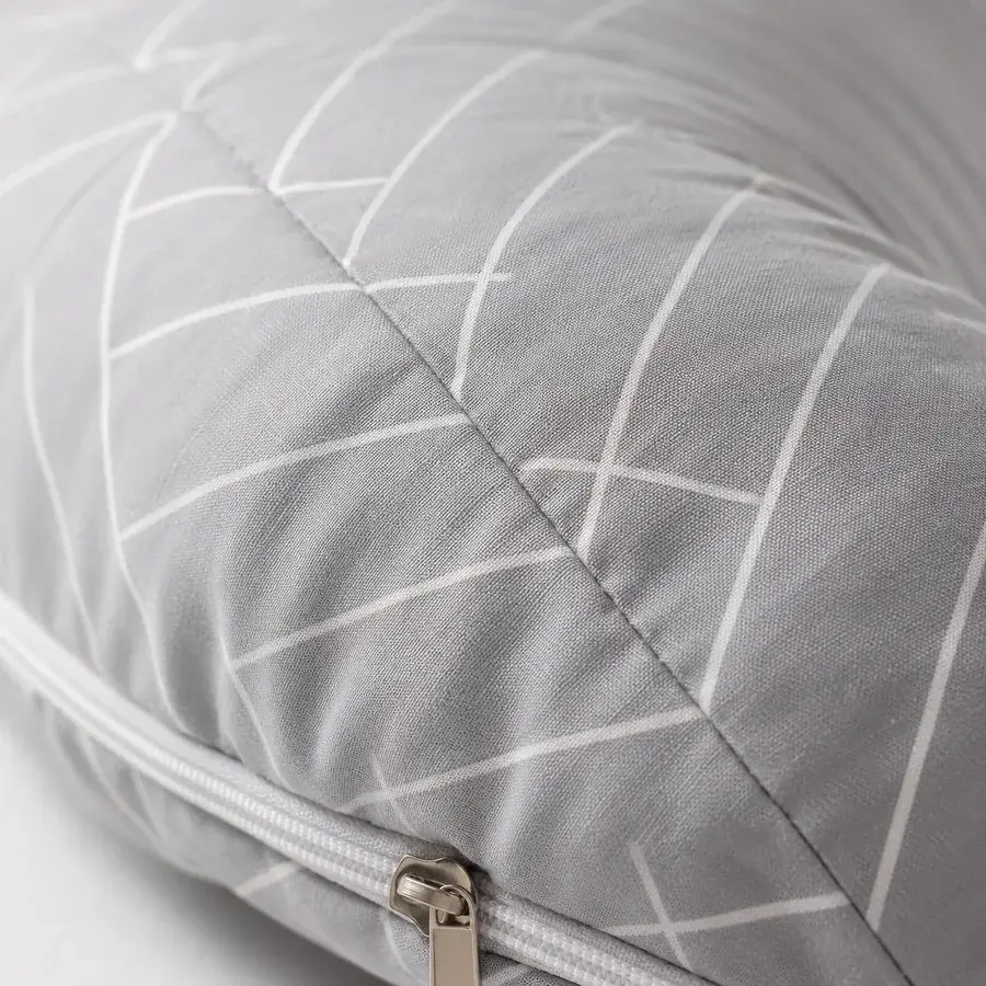 Close-up of the pillow’s seam and zip, grey fabric with fine white herringbone